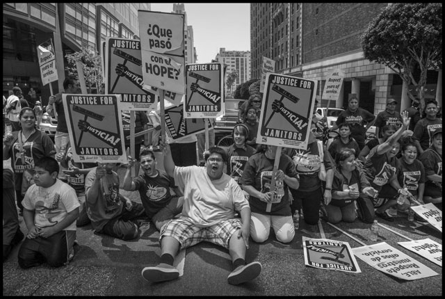 Members of the janitors union, United Service Workers West, sit down in a downtown Los Angeles intersection in 2011, to protest the firing of immigrant workers. (Photo: David Bacon)