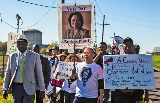 Pat Bryant (left) leading a march on River Road in the middle of Louisiana’s Cancer Alley against Entergy’s proposed gas plant and environmental racism. Behind the marchers is Entergy’s Waterford 3 Nuclear Power Plant.