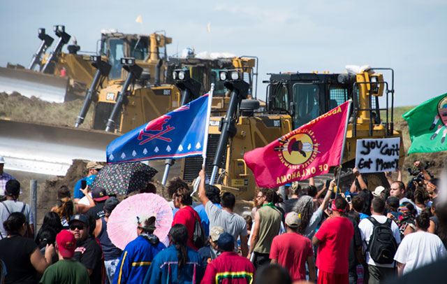 Members of the Standing Rock Sioux Tribe and their supporters opposed to the Dakota Access Pipeline confront bulldozers working on the new oil pipeline September 3, 2016, near Cannon Ball, North Dakota. Private security guards used pepper sprayed and attack dogs to attempt to repel the protestors. (Photo: Robyn Beck / AFP / Getty Images)