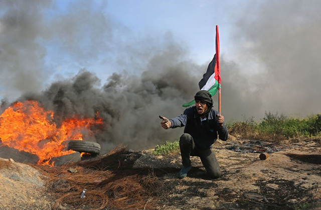 Palestinian protesters burn tires in response to Israeli forces' repression of a demonstration against Donald Trump's announcement to recognize Jerusalem as the capital of Israel and plans to relocate the US Embassy from Tel Aviv to Jerusalem, on March 09, 2018, near Israeli border in eastern part of Khan Yunis, Gaza. (Photo by Ashraf Amra/Anadolu Agency/Getty Images)
