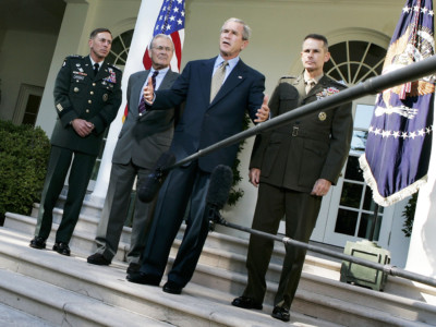 President George W. Bush speaks as Lt. Gen. David Petraeus, Secretary of Defense Donald Rumsfeld (2nd L), and Chairman of the Joint Chiefs of Staff Gen. Peter Pace (R) listen during a post-meeting briefing at the Rose Garden of the White House October 5, 2005, in Washington, DC.