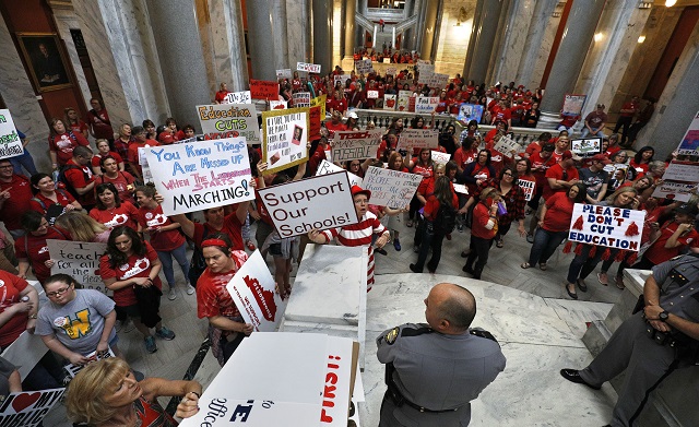 Kentucky public school teachers protest outside the Kentucky House Chamber as they rally for a day of action to pressure legislators to override Gov. Matt Bevin's recent veto of the state's tax and budget bills, April 13, 2018, in Frankfort, Kentucky. The teachers also oppose a controversial pension reform bill the governor signed into law.