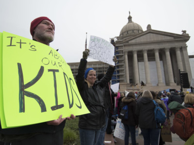 Kent Scott, a teacher from Tecumseh, Oklahoma, holds a protest sign at the state capitol on April 2, 2018, in Oklahoma City, Oklahoma. Thousands of teachers and supporters rallied Monday at the state Capitol calling for higher wages and better school funding.