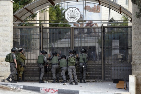 Israeli borderguards stand outside Al-Quds University in Abu Dis, a West Bank suburb of Jerusalem, close to the Israeli controversial separation wall during clashes with Palestinian demonstrators on November 2, 2015.