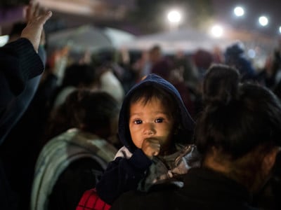 A prayer service is held for the group of Central American migrants at the San Ysidro border crossing while they wait to walk to the United States border and have their cases processed on April 30, 2018, in Tijuana, Mexico.