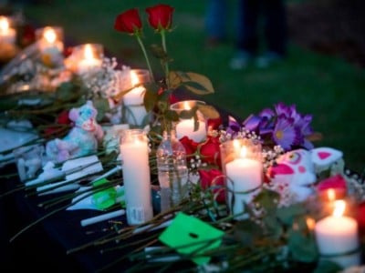 Candles, flowers and stuffed animals line a table during a vigil in Santa Fe, Texas for the victims of the mass shooting on May 18, 2018.