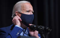 President Biden adjusts his mask as he speaks during a visit to the National Institutes of Health in Bethesda, Maryland, on February 11, 2021.