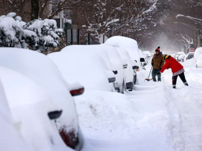 People work to dig out their car along a residential street on February 16, 2021, in Chicago, Illinois.