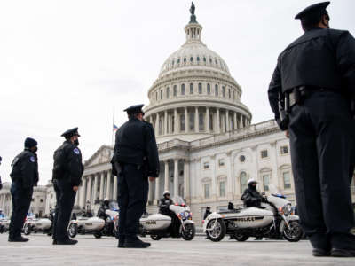 Members of the Capitol Police stand at attention as a police motorcade escort a hearse carrying the cremated remains of U.S. Capitol Police officer Brian Sicknick after lying in honor in the Rotunda in Washington on February 3, 2021.