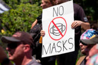 An anti-mask protestor holds up a sign in front of the Ohio Statehouse during a right-wing protest at the State Capitol on July 18, 2020, in Columbus, Ohio.