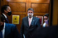 Sens. Joe Manchin, center, and Mitt Romney are seen before a series of Senate votes in the Capitol on February 4, 2021.