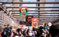 Thousands of protesters march across the Brooklyn Bridge with painted portraits of George Floyd in the Manhattan Borough of New York on June 19, 2020.