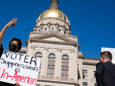 Demonstrators stand outside of the Capitol building on March 8, 2021, in Atlanta, Georgia.