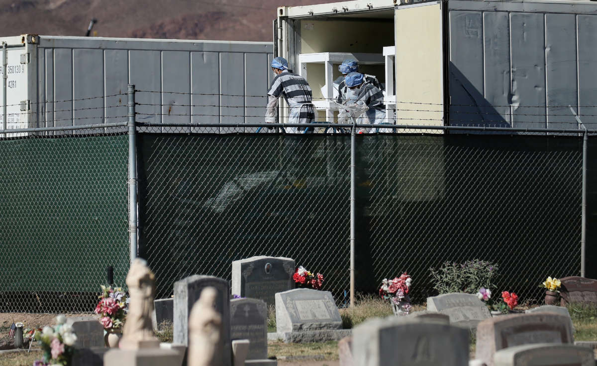 Low-level inmates from El Paso County detention facility prepare to load bodies wrapped in plastic into a refrigerated temporary morgue trailer in a parking lot of the El Paso County Medical Examiner's office on November 16, 2020, in El Paso, Texas.