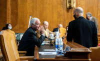 Sen. Ron Johnson (left) speaks to Sen. Rick Scott prior to a confirmation hearing before the Senate Budget Committee on February 10, 2021, at the U.S. Capitol in Washington, D.C.