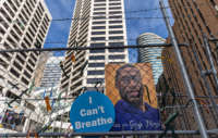 A poster with George Floyd's picture and a sign reads that "I Can't Breathe" hang from a security fence outside the Hennepin County Government Center on March 30, 2021, in Minneapolis, Minnesota.