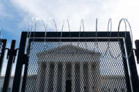 Razor wire-topped riot fencing stands in front of the U.S. Supreme Court on March 15, 2021.