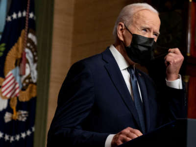 President Joe Biden removes his mask to speak from the Treaty Room in the White House on April 14, 2021, in Washington, D.C.
