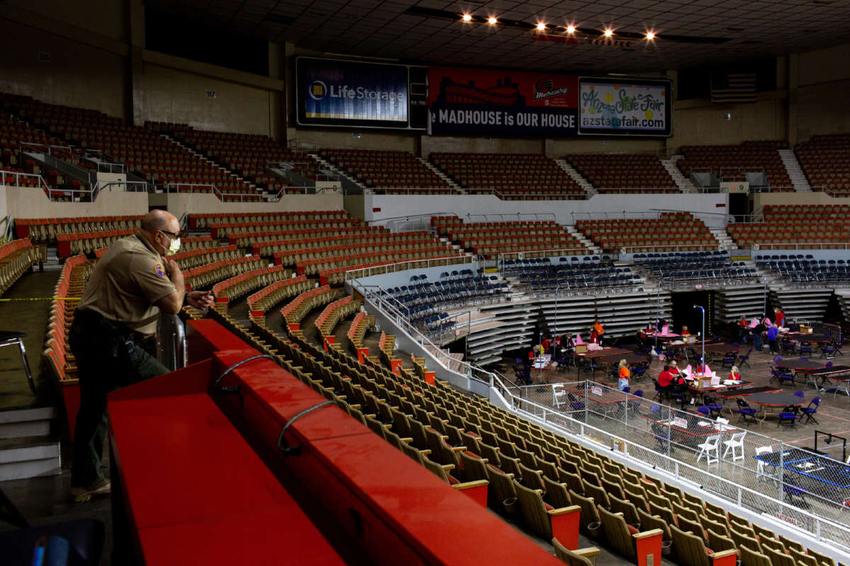 An Arizona Ranger watches as contractors working for Cyber Ninjas, who was hired by the Arizona State Senate, examine and recount ballots from the 2020 general election at Veterans Memorial Coliseum on May 1, 2021, in Phoenix, Arizona. The Maricopa County ballot recount comes after two election audits found no evidence of widespread fraud.