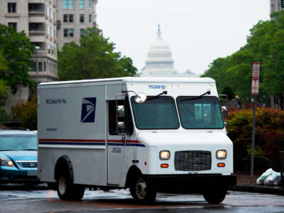 A U.S. Postal Service truck drives down Pennsylvania Avenue, with the U.S. Capitol in the background in Washington, D.C., on April 23, 2020.