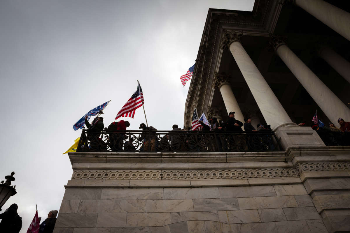 Trump supporters wave flags from a platform on the Capitol Building on January 6, 2021, in Washington, D.C.