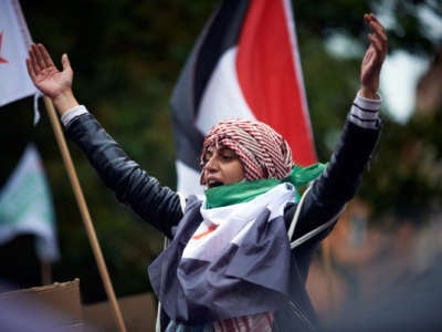 An activist raises their hands during a demonstration in support of Palestine