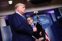 President Donald Trump arrives as Attorney General William Barr looks on during a briefing at the White House on March 23, 2020, in Washington, D.C.