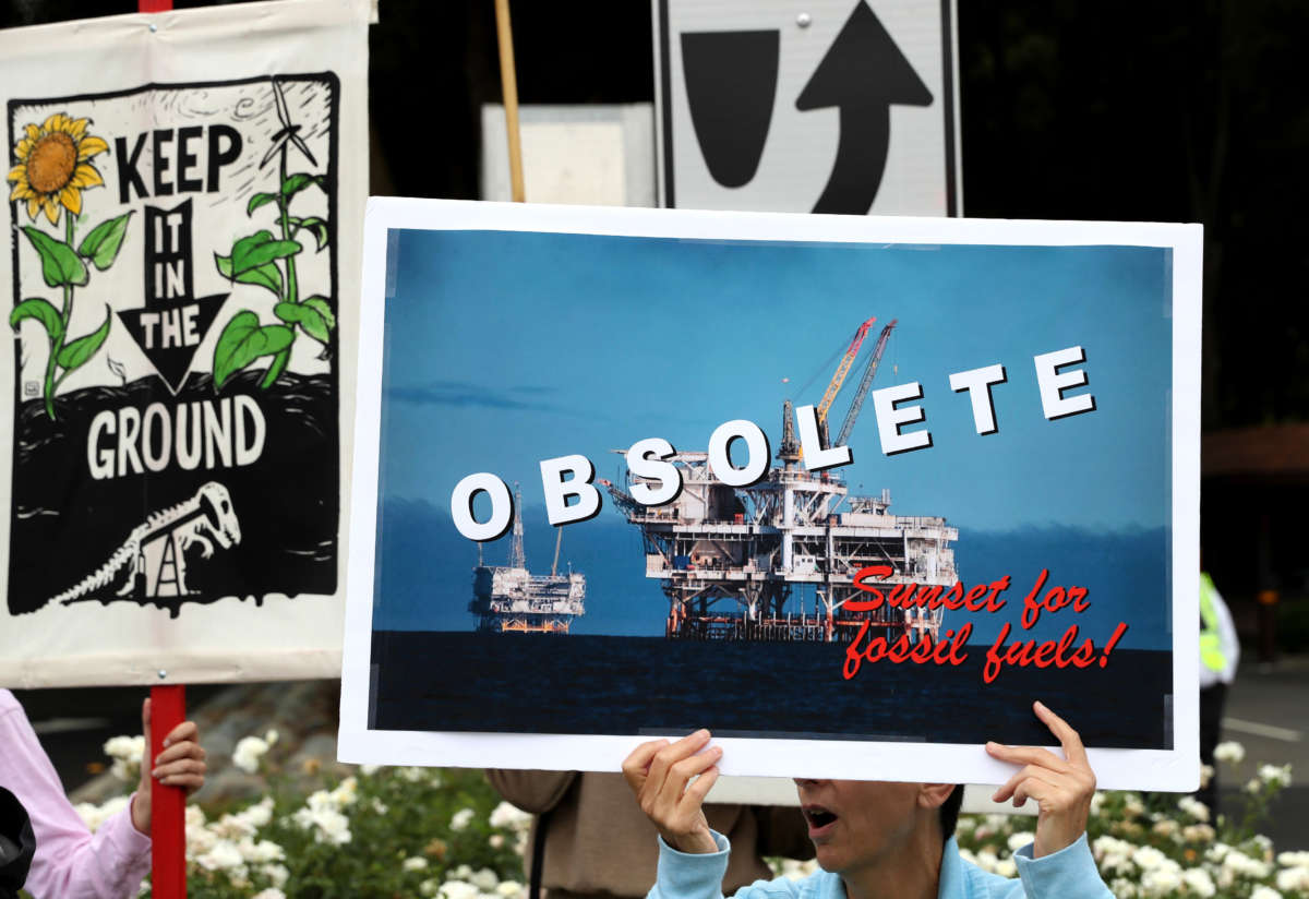 A climate activist holds a sign during a Climate Strike youth protest outside of Chevron headquarters on September 27, 2019, in San Ramon, California.