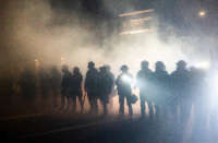 Oregon State Troopers and Portland police advance through tear gas while dispersing a protest against police brutality and racial injustice on September 5, 2020, in Portland, Oregon.