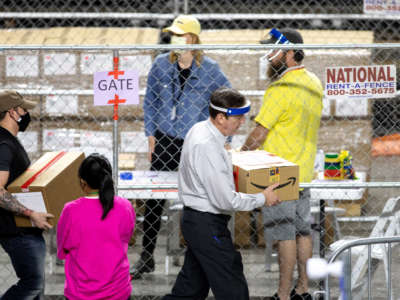 Former Secretary of State Ken Bennett, right, works to move ballots from the 2020 general election at Veterans Memorial Coliseum on May 1, 2021, in Phoenix, Arizona. The Maricopa County ballot recount comes after two election audits found no evidence of widespread fraud in Arizona.
