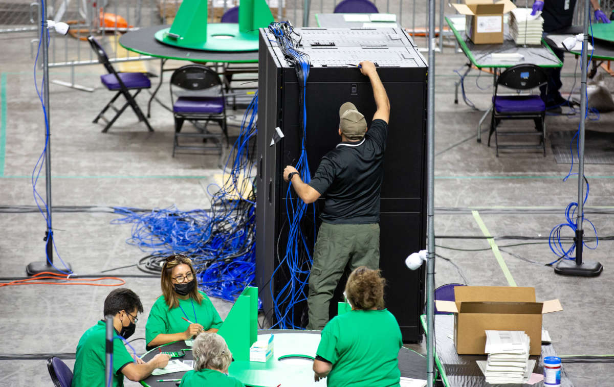 Contractors working for Cyber Ninjas, a company hired by the Arizona State Senate, examine and recount ballots from the 2020 general election on May 3, 2021, in Phoenix, Arizona.