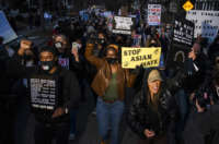 People march through a neighborhood to protest against anti-Asian violence on March 18, 2021, in Minneapolis, Minnesota.