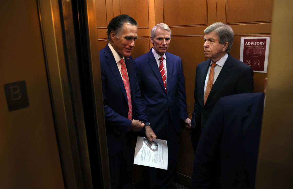 From left, Sens. Mitt Romney, Rob Portman and Roy Blunt ride an elevator as they leave a bipartisan meeting on infrastructure at the U.S. Capitol on July 13, 2021, in Washington, D.C.