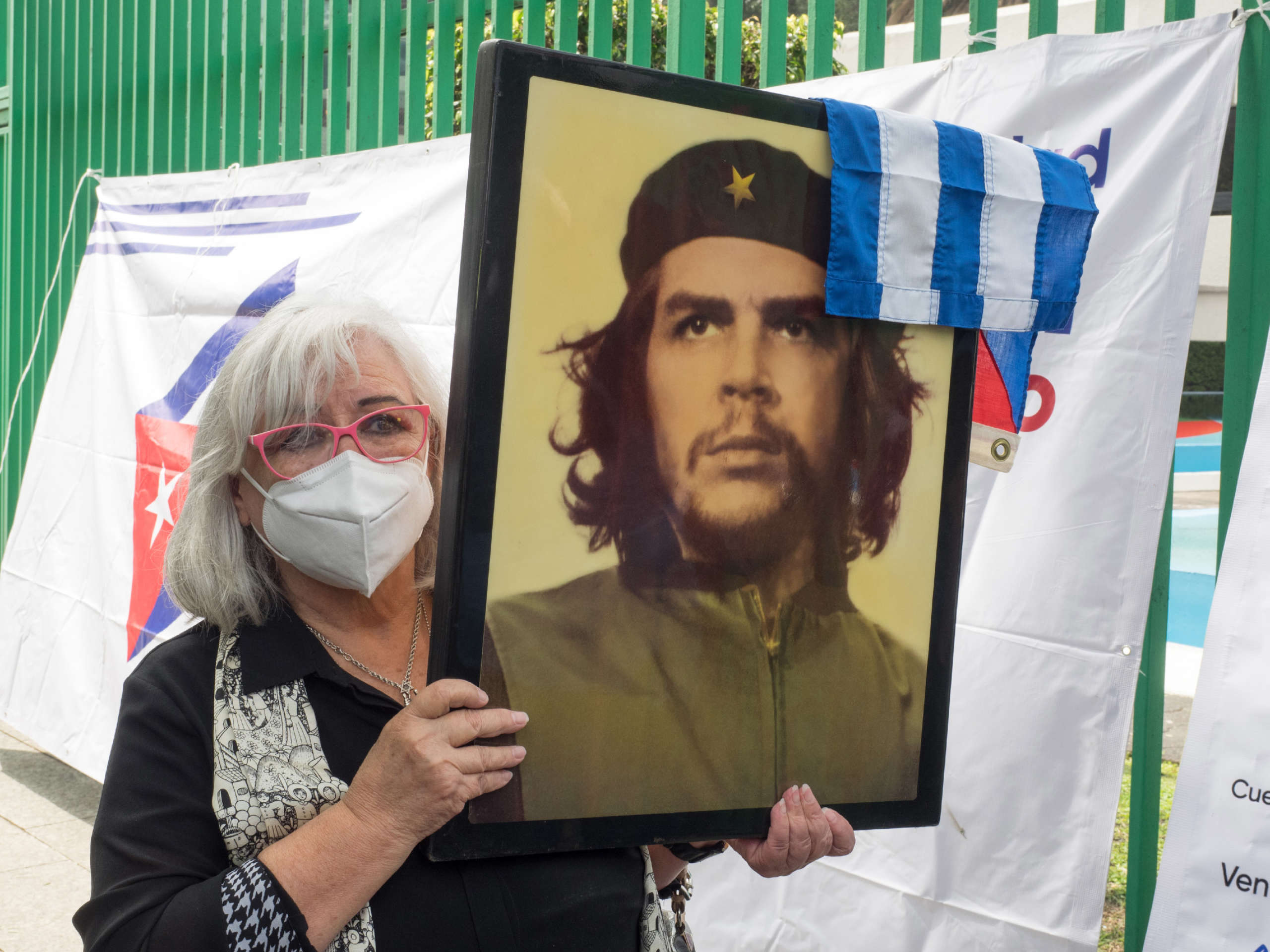 A woman holds up a picture of Latin American revolutionary Ernesto "Che" Guevara during a demonstration in solidarity with the Cuban Revolution in front of the Cuban embassy in Mexico City, Mexico, July 17, 2021.