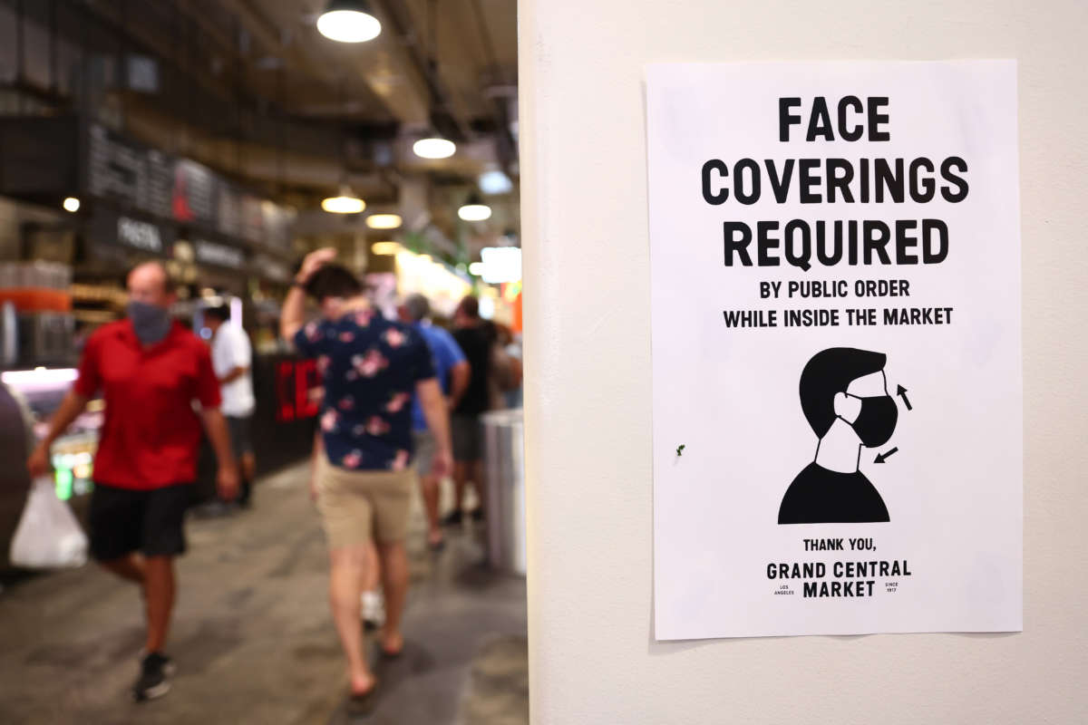 A sign is posted about required face coverings in Grand Central Market on July 19, 2021, in Los Angeles, California.