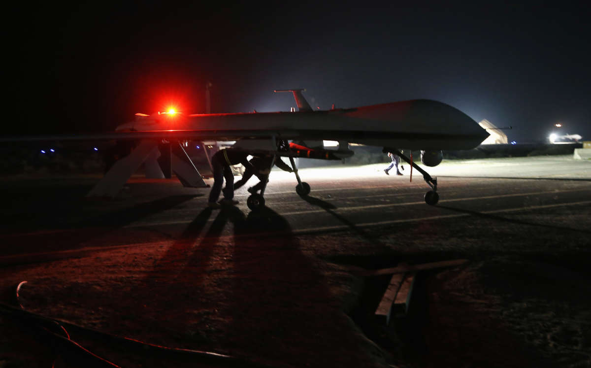 Contract workers push a U.S. Air Force MQ-1B Predator unmanned aerial vehicle after it flew a mission from an air base in the Persian Gulf region on January 7, 2016.