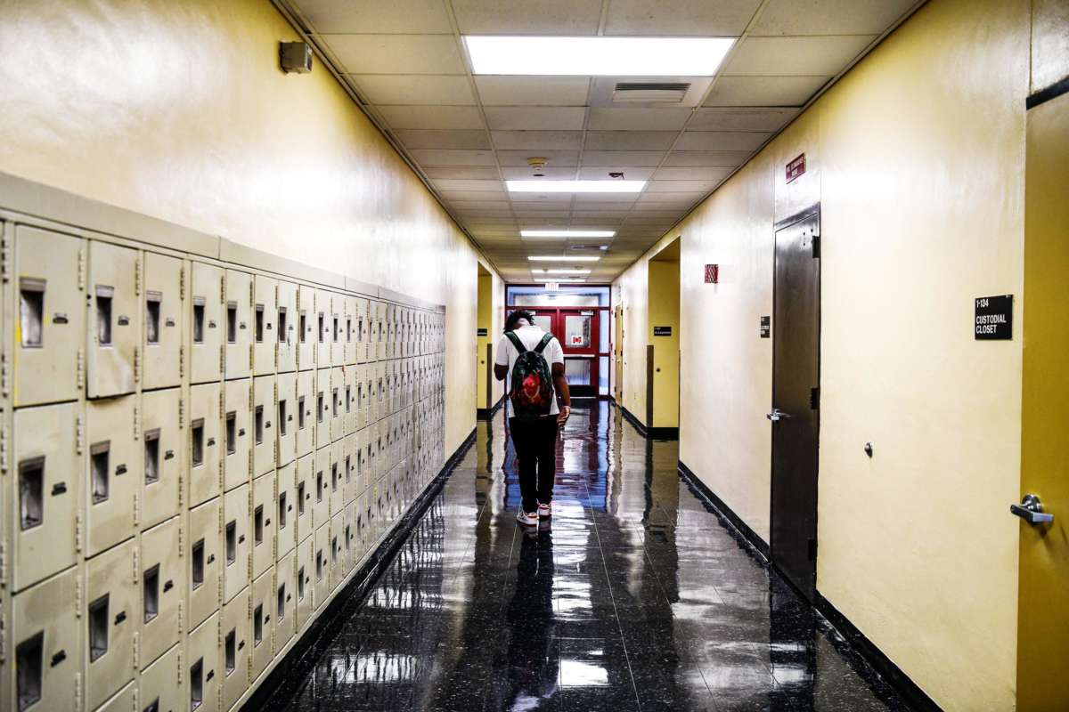 A student walks down an empty school hallway