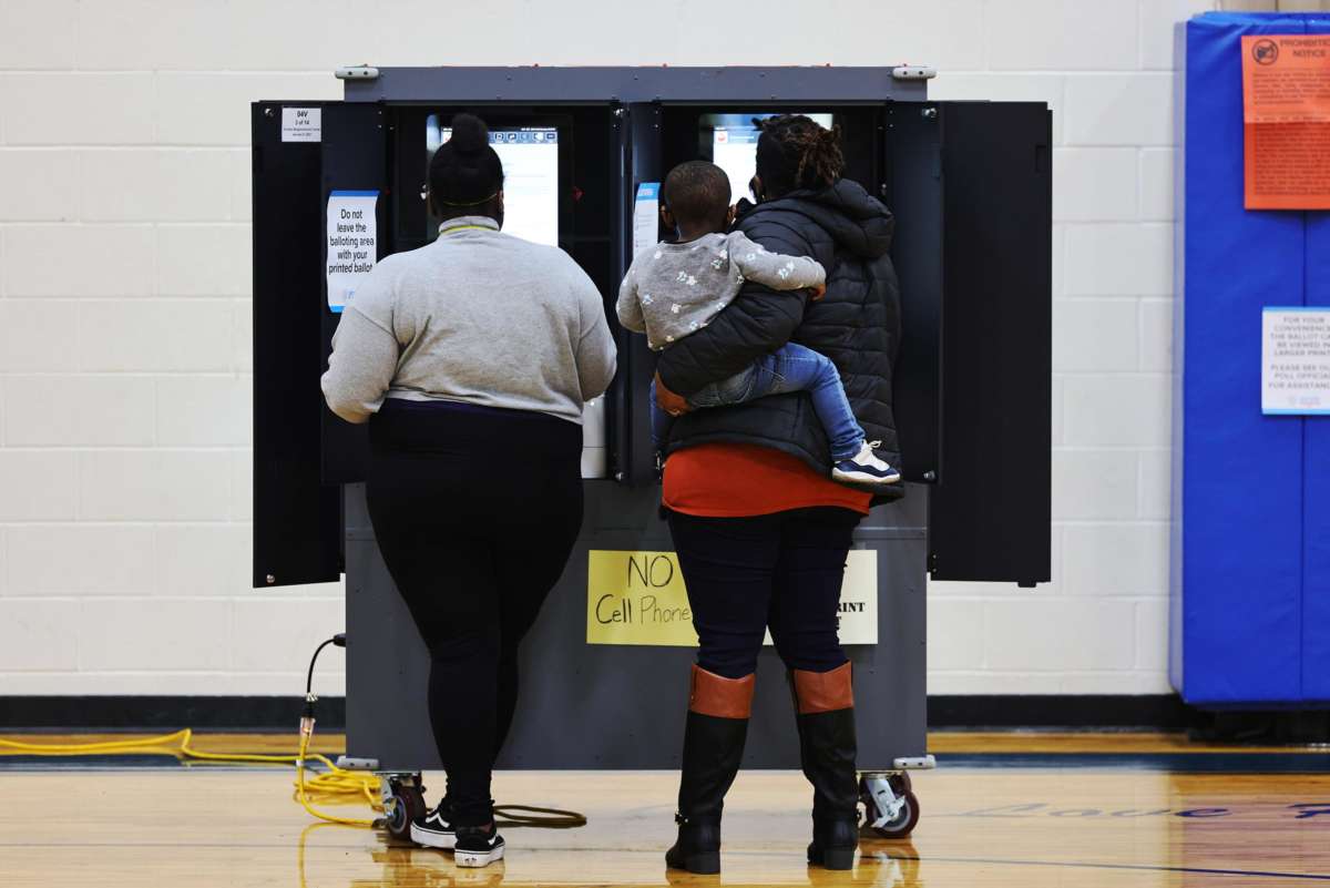 People cast their votes at a voting machine