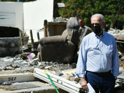 President Joseph Robinette Biden gazes over wreckage