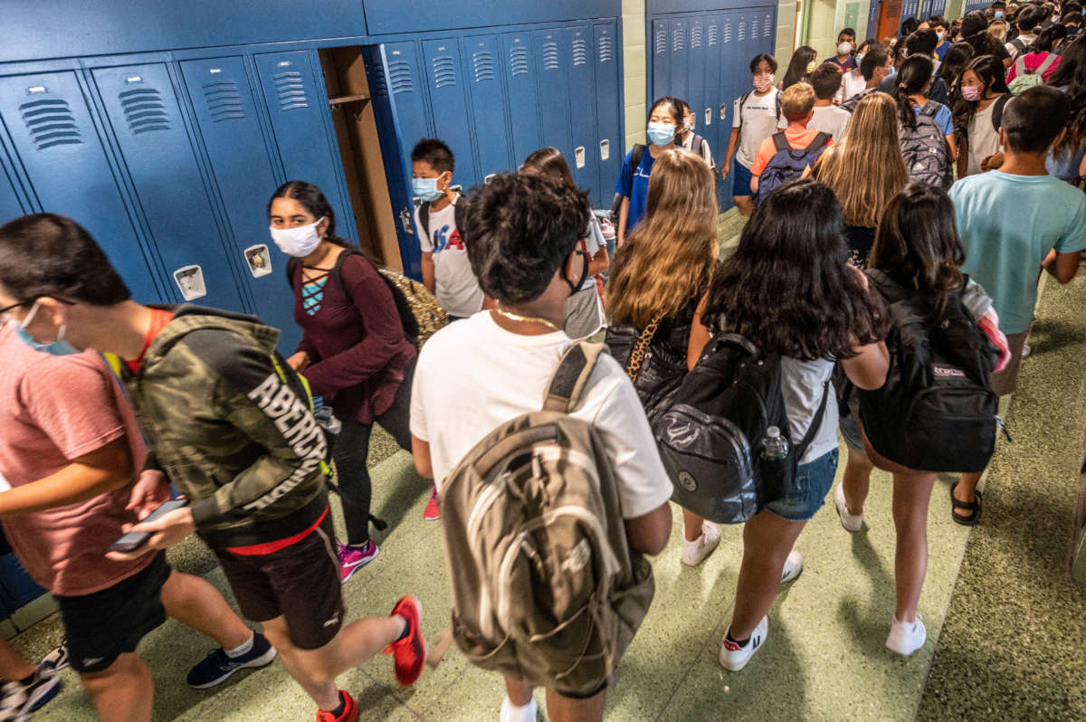 Students walk through the hallway wearing masks as they return to class on the first day of school at the Jericho, New York, school district on August 26, 2021.