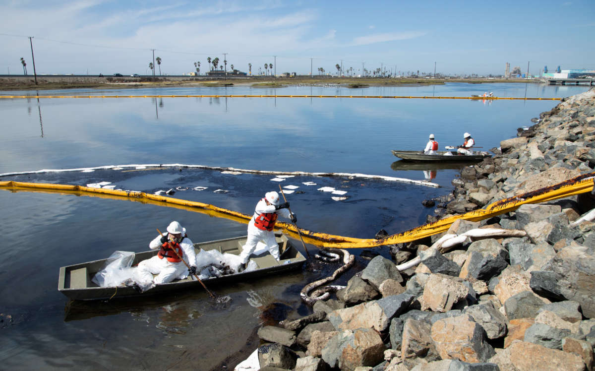 Workers with Patriot Environmental Services clean up oil that flowed into the Talbert Marsh in Huntington Beach on October 3, 2021.
