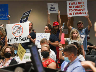 People demonstrate with placards at an emergency meeting of the Brevard County, Florida School Board in Viera to discuss whether face masks in local schools should be mandatory, on August 30, 2021.
