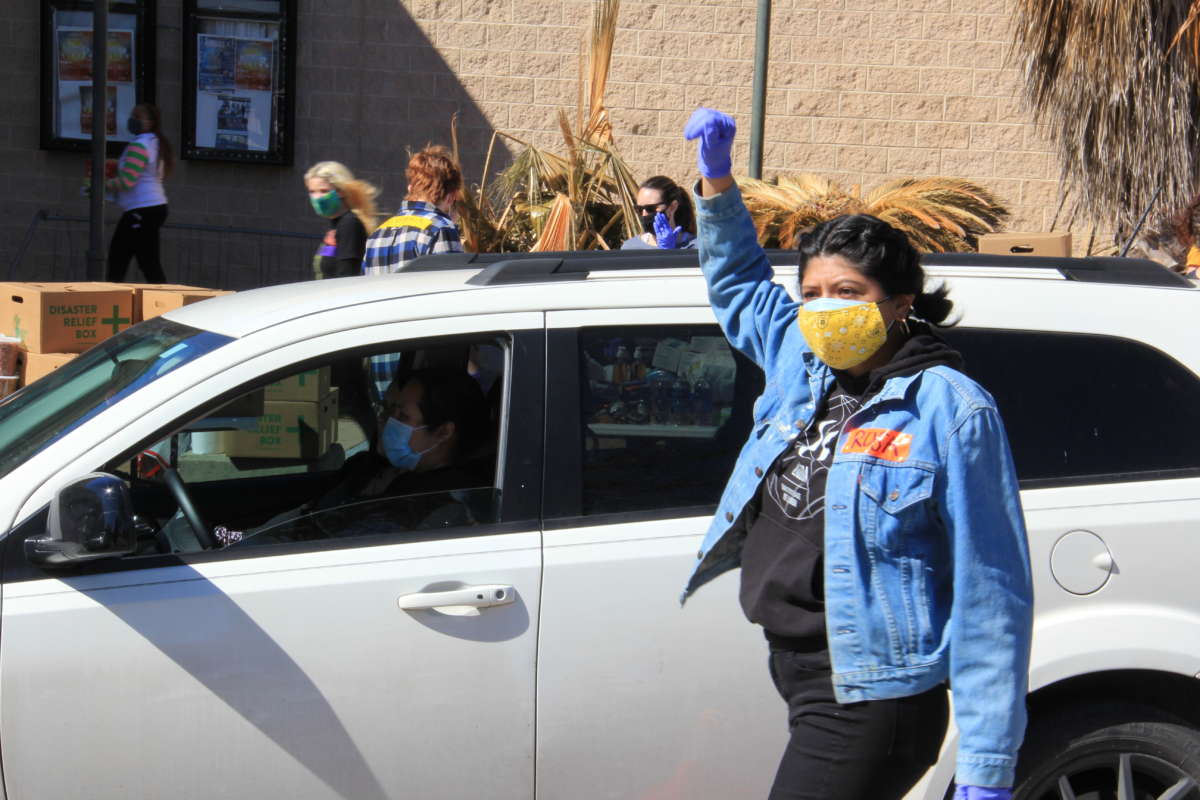 A disaster aid volunteer waves a car through to receive emergency supplies at an impromptu distribution site at the Millennium Youth Entertainment Complex in Austin, Texas, on February 20, 2021.