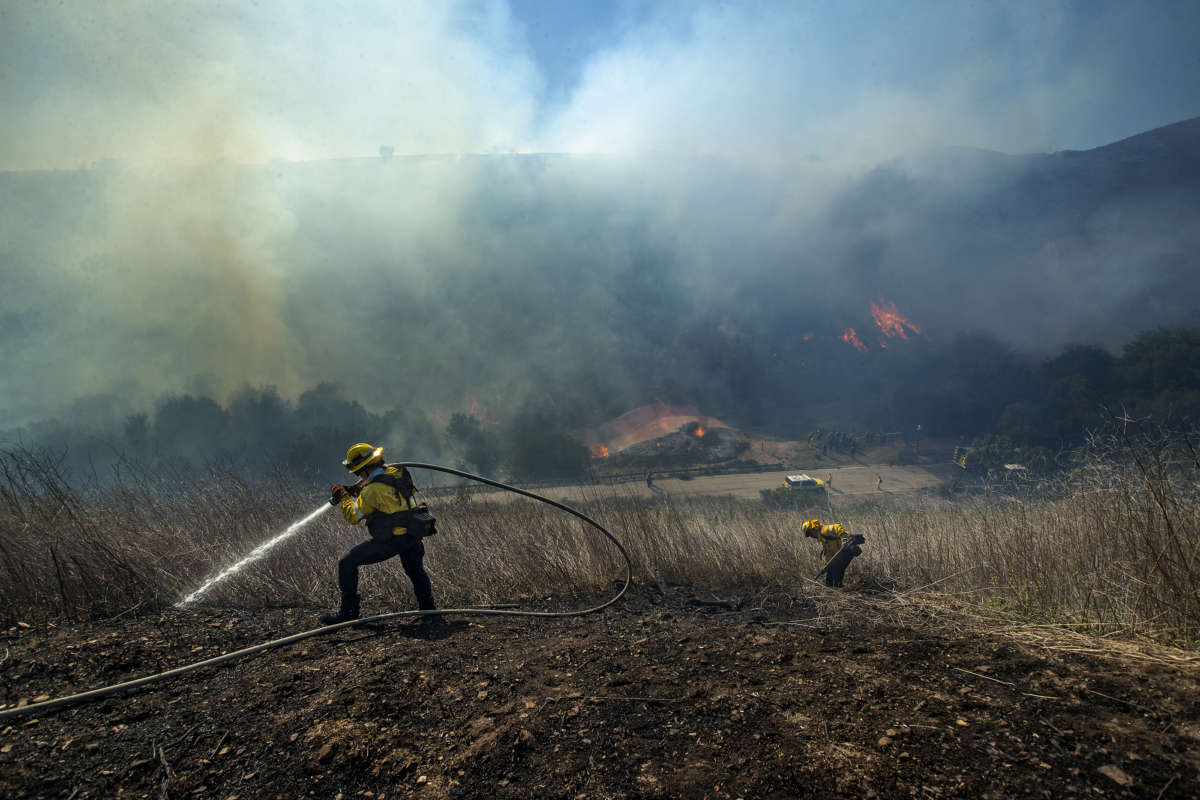 Los Angeles County Firefighters put out hot spot on a brush fire, estimated at 24 acres, in Westlake Village, California, on April 29, 2021.