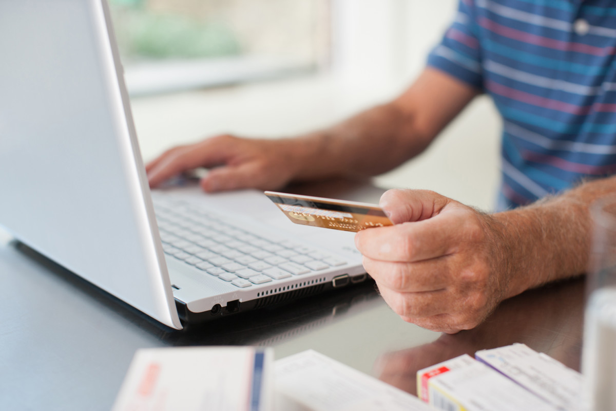 Close up of man using credit card to purchase merchandise online