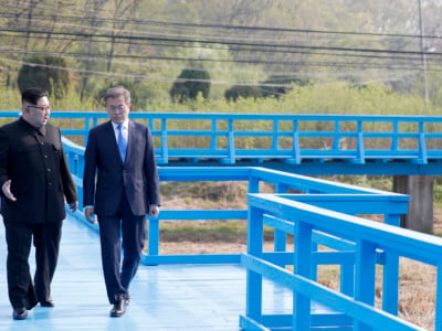North Korea's leader Kim Jong Un and South Korea's President Moon Jae-in walk on a bridge after a tree-planting ceremony at the truce village of Panmunjom on April 27, 2018.