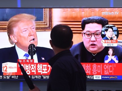 A man walks past a television news screen at a railway station in Seoul, South Korea, showing North Korean leader Kim Jong Un and Donald Trump on May 16, 2018.
