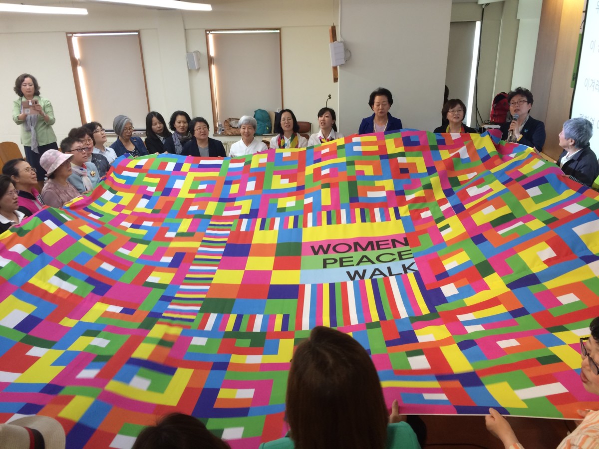 Women hold a quilt symbolizing peace and unity between people on the Korean Peninsula during last year's women's peace symposium in Seoul.