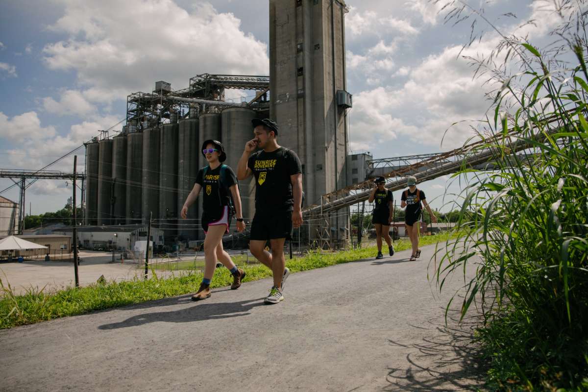 Demonstrators walk past grain silos
