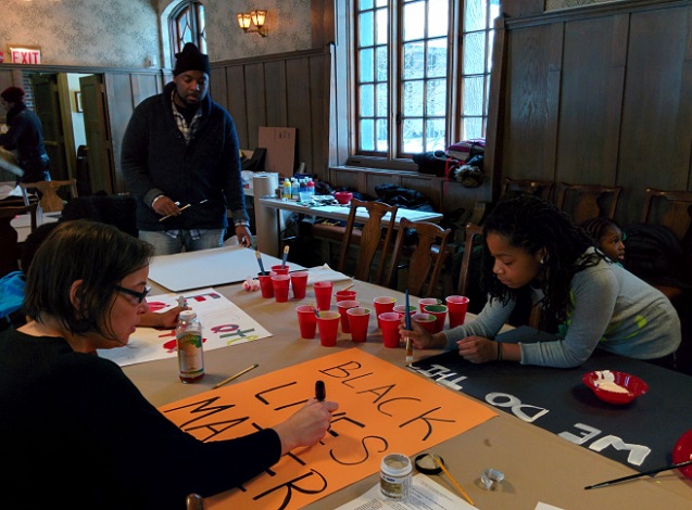 Youth organizer Jakya Hobbs works alongside adult allies to create signage for Chicago’s installment of Reclaim MLK. (Photo: Kelly Hayes)
